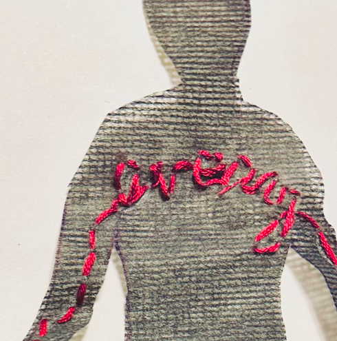 Close-up of a black textile figure with red stitching, artwork by Meadow Jones